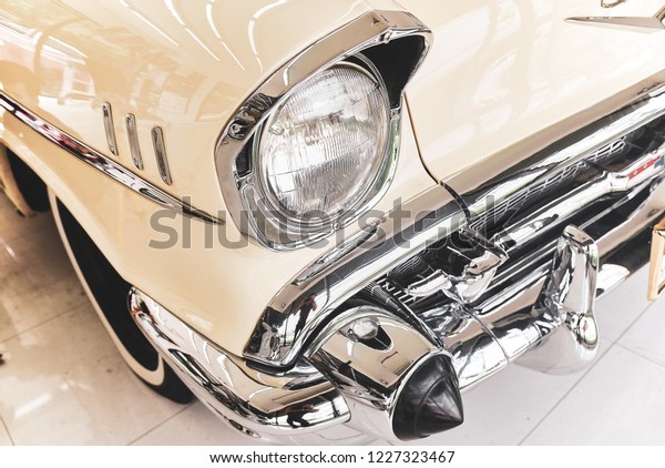 BANGKOK, THAILAND - APRIL 5, 2018; close up\
of Chevrolet Bel Air headlight & chrome bumper. Retro vehicle.\
Concept of old automotive restoration & auto detailing.\
Classic & vintage car background.\
