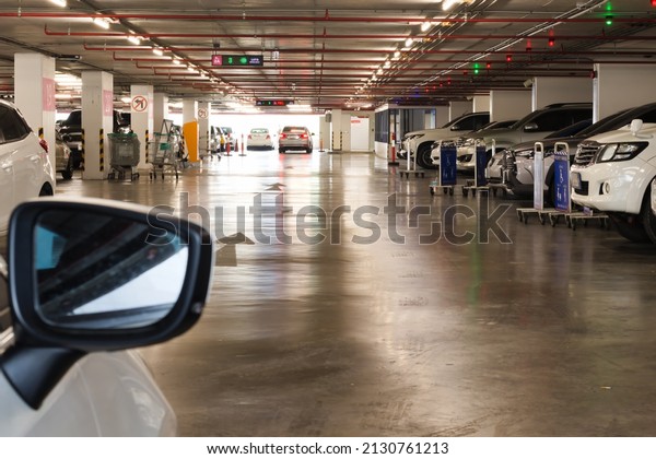 Bangkok, Thailand - April 5, 2021 : Smart parking
guidance in department store with light overhead, car lot. From car
side mirror.