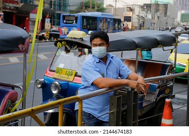 Bangkok, Thailand - April 8, 2022: Tuk-tuk Driver, Wearing A Face Mask To Prevent The Spread Of COVID-19 And To Protect From The Bad Air Quality, Wait For Passengers In Ratchathewi Neighborhood.