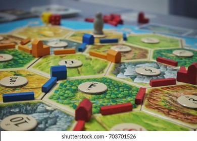 Bangkok, Thailand - Aug 19th, 2017. Board game party with my friends. Settlers of Catan, popular board game. Players are scrambling the area to get more resources and victory points.