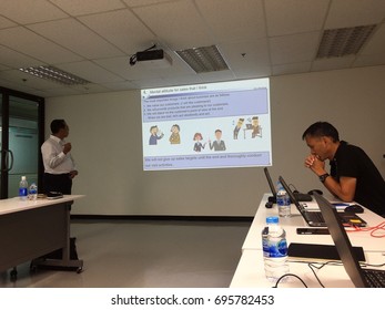 BANGKOK, THAILAND - AUGUST 10, 2017: An Asian Man Gives A PowerPoint Presentation To Other People In The Meeting Room.