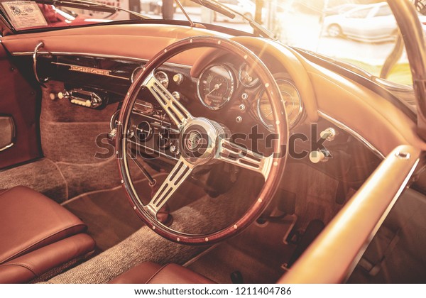 BANGKOK, THAILAND - AUGUST 10, 2017: Porsche\
356 Speedster brown leather interior with actual sunlight flare.\
Classic car dashboard & steering wheel. Concept of vintage car\
& retro car\
restoration.