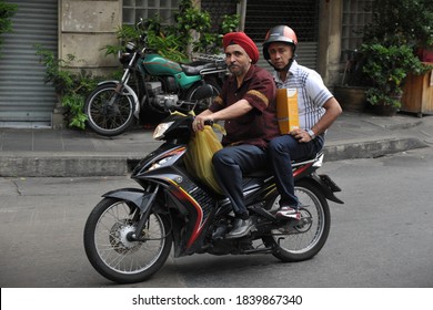 Bangkok, Thailand - August 2, 2012: A Man Wearing A Sikh Turban Rides A Motorbike Along A City Centre Street. People Who Wear Religious Headwear Are Except From Motorcycle Helmet Laws In Thailand.