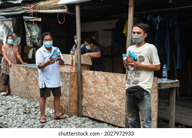 BANGKOK, THAILAND - AUGUST 2021: Food And Hygiene Supplies Give Away To Poor People In Slums. Thai Asian Low Income Community Wear Face Masks Over COVID-19 And Receive Support From Volunteers