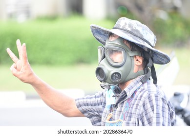 Bangkok, Thailand: August 21, 2021 This Man, Wearing A Tear Gas Mask, Sells Goods In A Protest Area. Din Daeng Intersection.