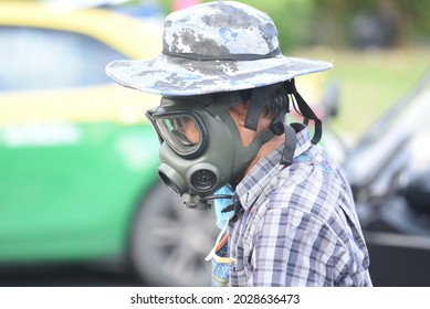 Bangkok, Thailand: August 21, 2021 This Man, Wearing A Tear Gas Mask, Sells Goods In A Protest Area. Din Daeng Intersection.