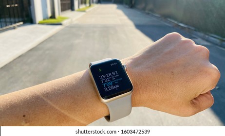 Bangkok, Thailand - Dec 10, 2019 : Close Up Runner Check Running Summary Against Along Road Background. Running Athletes Open Activities App On Apple Watch While Run Workout In Sunshine Morning