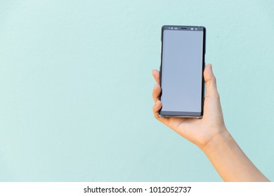 BANGKOK, THAILAND : Dec 30, 2017 - Woman hold smart phone Samsung galaxy note 8 (Android OS) on blue concrete background - Shutterstock ID 1012052737