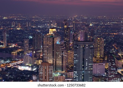 BANGKOK, THAILAND - DECEMBER 05 2018 : Night aerial view of Lebua at state tower and other buildings in Bangkok, Thailand with the view of Chao Praya river.