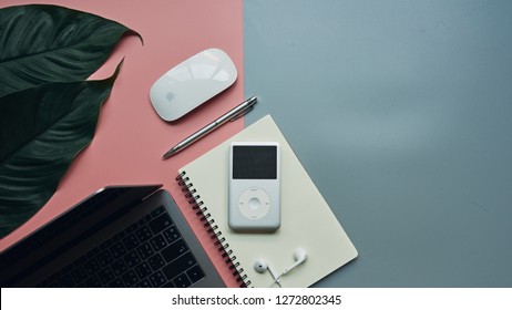 BANGKOK, THAILAND - December 12, 2018: Flat lay of iPod classic 160GB with leaf, notebook and pencil on pink and blue background