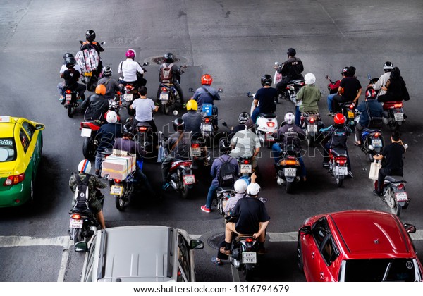 Bangkok, Thailand - December 15, 2016 : The\
motorcycle and car wait for light signal when it show a red light\
while more people use motorcycle in every day life in the heavy\
traffic in Bangkok is\
prob