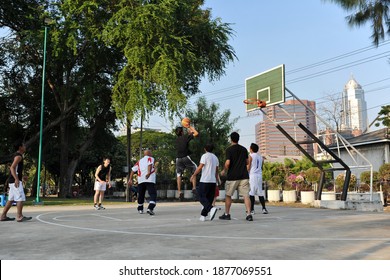 Bangkok, Thailand - December 18, 2011: Men play basketball at an informal meet on a court in Lumpini park. Lumpini is the Thai capital's largest public park and home to numerous sports facilities.