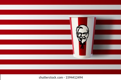 BANGKOK, THAILAND - December 18, 2019: KFC soft drink paper cup on red striped background. KFC is an American fast food restaurant chain known as Kentucky Fried Chicken. Illustrative editorial