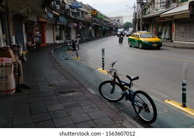 Bangkok, Thailand - December, 2015: Bicycle Parked On Bike Path Along The Road. Traditional Bangkok Taxi Car Driving On The Street In Khaosan Road Tourist Area. Morning Street With No People.