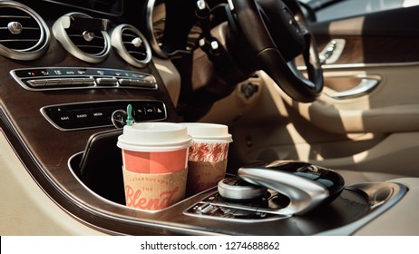 BANGKOK, THAILAND - December 23, 2018: Close up of Red designed Starbucks coffee cup on cup holders in between front car seats