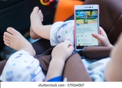 Bangkok, Thailand - FEB 13, 2017: Asian Toddler Baby Boy Sitting In Car Seat And Watching A Video From Youtube On Huawei Android Smartphone. Bird Eye View (Shallow Depth Of Field & Selective Focus)