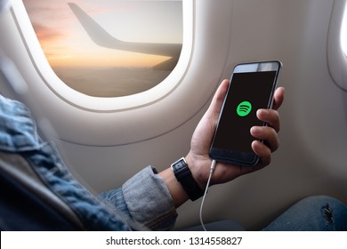 Bangkok. Thailand. FEB 16,2019 :Man holding a iPhone 6 Space Gray on a plane with music service Spotify on the screen. iPhone 6 was created and developed by the Apple inc.