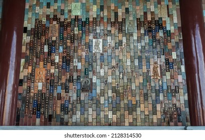 Bangkok, Thailand - Feb 19, 2022 : Chinese lettering teachings and Carved buddha images into a slab of colored tiles on temple wall of Fo Guang San Temple. No focus, specifically.