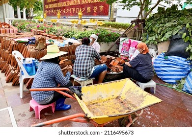 BANGKOK, THAILAND - February 01, 2022 : Asian woman worker They are helping to clean the temple roof tiles in order to prepare the temple roof.