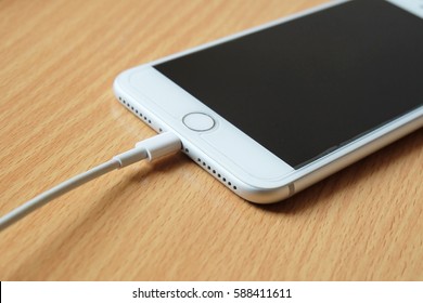 Bangkok, Thailand - February 11, 2017: Close-up iPhone 7 plus connect to usb cable on desk.