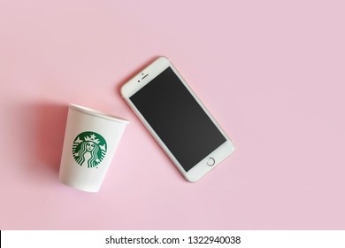 Bangkok ,Thailand - February 11 2019 : A Flat Lay Of Starbuck Coffee Cup With IPhone 6s Plus On Pink Background.