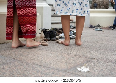 Bangkok, Thailand, February, 16, 2022: Bare Feet Of Two People Praying In A Buddhist Temple