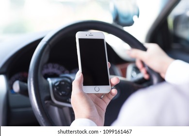 Bangkok, Thailand,- February 2, 2018 : He looking at mobile phone while driving a car
