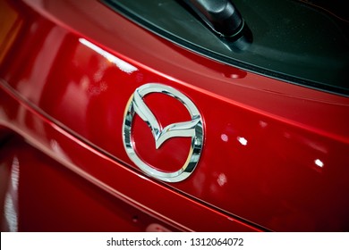 BANGKOK, THAILAND - FEBRUARY 2, 2019: Taillight of Mazda 3 modern sporty hatchback with reflection on rear red paint after paint polishing and coating. Illustration of car detailing and restoration. 