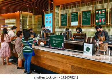 Bangkok, Thailand - February 21 ,2021:  Cashier at the cash register in Starbucks Reserve® Chao Phraya Riverfront marks Starbucks 417th store at ICONSIAM in Thailand