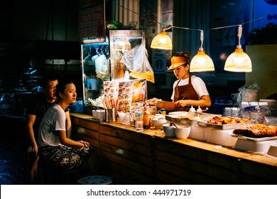 BANGKOK, THAILAND - FEBRUARY 26, 2016: People Are Buying Food At Night Street Food Market In Bangkok, Thailand.