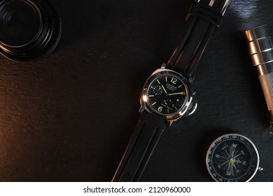 Bangkok, Thailand, February 9 2022, wrist watch brand Panerai luminor model is displayed on  black wooden table shelf with a compass, torch, and camera lens in the authorized dealer in Panerai shop 