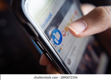 Bangkok, Thailand - January 10, 2021 : Facebook user touches on the like button in Facebook app.
