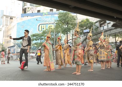 Bangkok, Thailand - January 14, 2015 Man Riding Unicycle Taking Selfie With Group Of Thai Traditional Dancers Within 