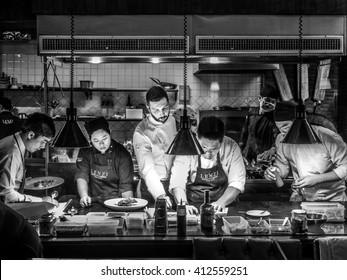 BANGKOK, THAILAND - January 16, 2016: Head Chef Coaches His Team In A Busy Italian Tuscan Kitchen. Kitchen Display Systems (KDS) In Back Of The House (BOH) Operations