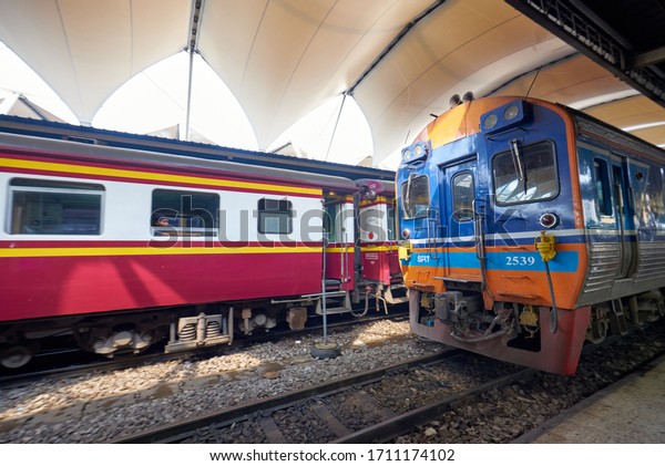 Bangkok, Thailand - January 2020: An employee\
washes a railway passenger car, A group of workers washes train\
cars at the Bangkok main train\
station