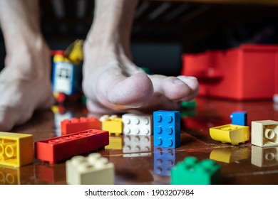 Bangkok, Thailand - January 27, 2021 : A man avoids to stepping on Lego bricks on the floor.