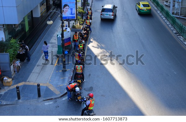 Bangkok, Thailand - January 6, 2020 : Group of\
motorcycle taxis of a mtorcycle queue at Silom road waiting for\
passengers. Travel by motorbike taxi is popular in Bangkok during\
rush hour