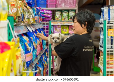 Bangkok, Thailand - January 7, 2017 : Women And Her Dog Shop A Pet Food (Dog, Cat And Other) On Pet Goods Shelf In Pet Shop.