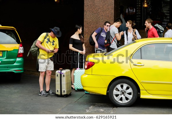 Bangkok, Thailand - January 7, 2017 : The\
tourist wait a cab. Get taxi easiest ways to go around Bangkok by\
booking through an application is very\
easy.