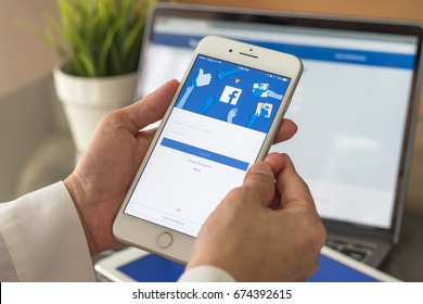 BANGKOK, THAILAND - July 10, 2017: Facebook social media app logo on log-in, sign-up registration page on mobile app screen on iPhone smart devices in business person's hand