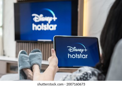 Bangkok, Thailand - July 13, 2021: Disney+ Hotstar movie app logo on ipad and smart TV television screen sharing in home living room for popular TV show watching during new normal lifestyle