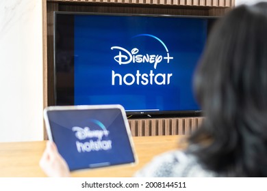 Bangkok, Thailand - July 13, 2021: Disney+ Hotstar Movie App Logo On Ipad And Smart TV Television Screen Sharing In Home Living Room For Popular TV Show Watching During New Normal Lifestyle