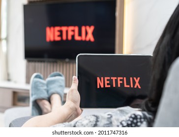 Bangkok, Thailand - July 13, 2021: Netflix App Logo On Ipad And Smart TV Television Screen Sharing In Home Living Room For Movie Watching During New Normal Lifestyle