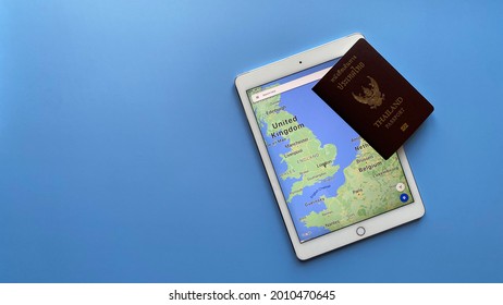 Bangkok, Thailand - July 17, 2021: Top View Flat Lay Of Ipad Shown Google Map With Passport On Blue Background With Copy Space For You Text