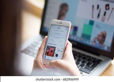 Bangkok. Thailand - July 20, 2017 :A woman is typing on ebay search engine from phone and laptop; ebay Websites that sell - sell - auction online Market Place is one of the most popular in the world.