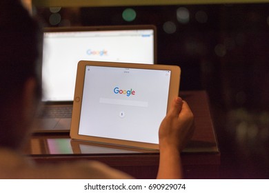 BANGKOK, THAILAND - July 29, 2017: Business Woman Using Mini Ipad With Macbook Pro With Google Search Engine On Web Page   Working At Night  From Home