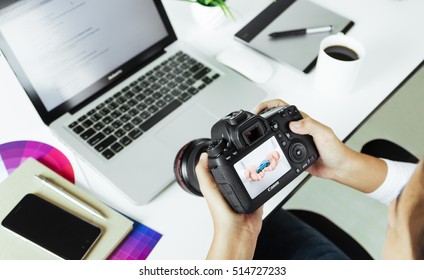 Bangkok, Thailand - July 30, 2016: Photographer Checking Camera Canon 6d Model Device On Desk, Canon Camera Is Manufactured By Canon Inc.,