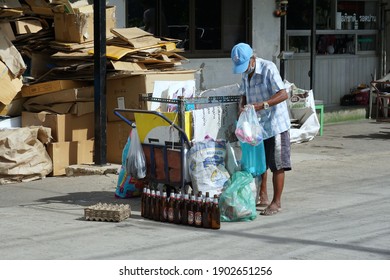 Bangkok, Thailand- July 5,2020 : Asian man takes recycle items to sell at recycling station for further action. Cardboard box background. Recycling for saving environment, energy and waste management.