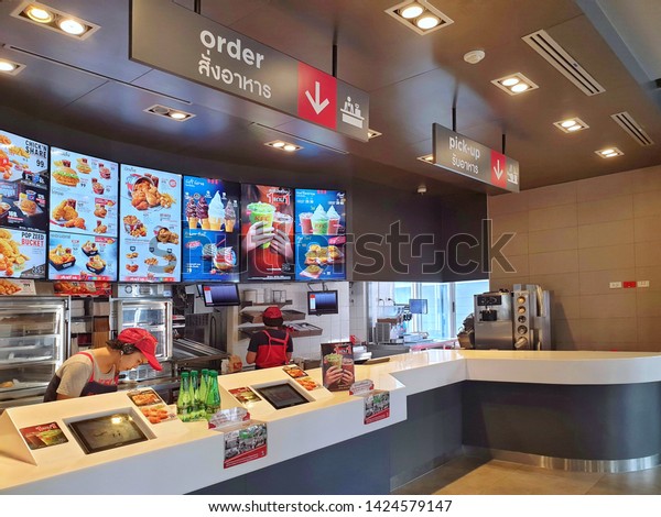 Bangkok, Thailand - June\
15,2019: KFC drive thru on Ramintra Rd., Opposite Synphaet\
Hospital. KFC is a fast food restaurant chain that specializes in\
fried chicken