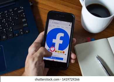 Bangkok, Thailand - June 9, 2019 : Facebook user touch on love button in Facebook application on iPhone 7.